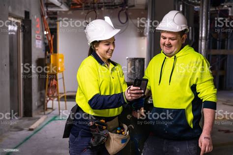 Real Life Female Electrician And Her Coworker At Work Stock Photo