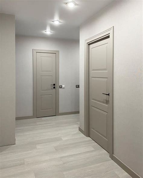 an empty hallway with two doors and three lights on the ceiling leading to another room