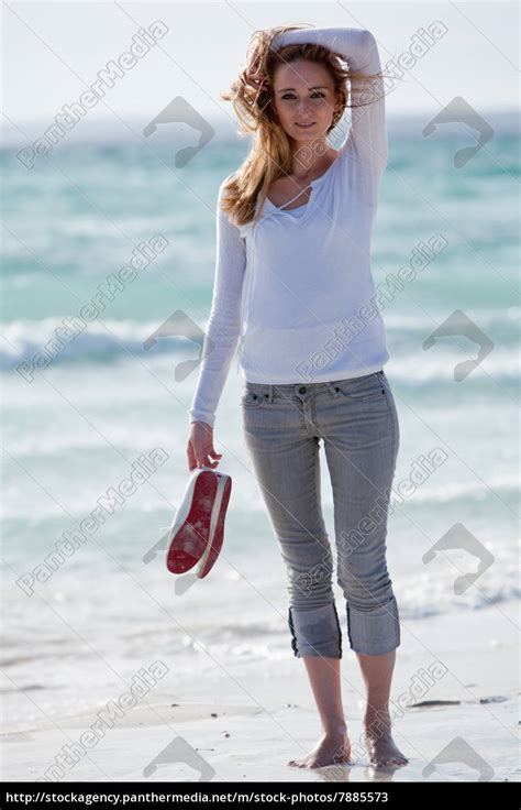 junge hübsche frau spaziert am strand im sand im Lizenzfreies Bild