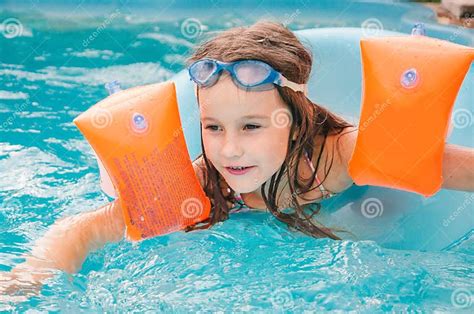 Little Girls Is Swimming In The Pool By A Summer Day Stock Photo