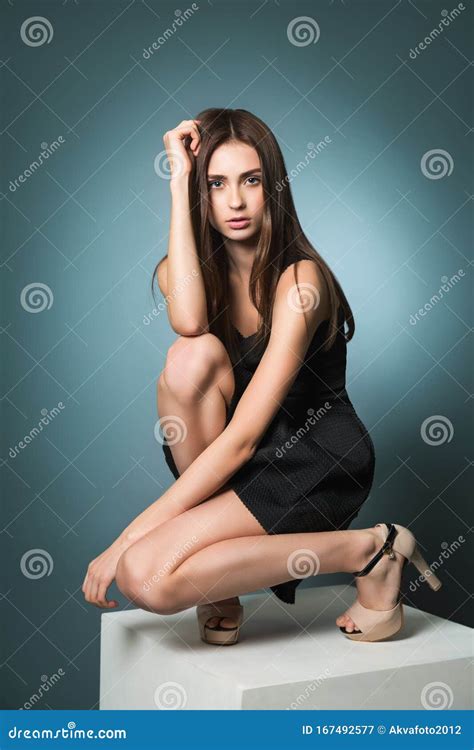 Beautiful Model Posing In The Studio A Girl In A Black Dress And High