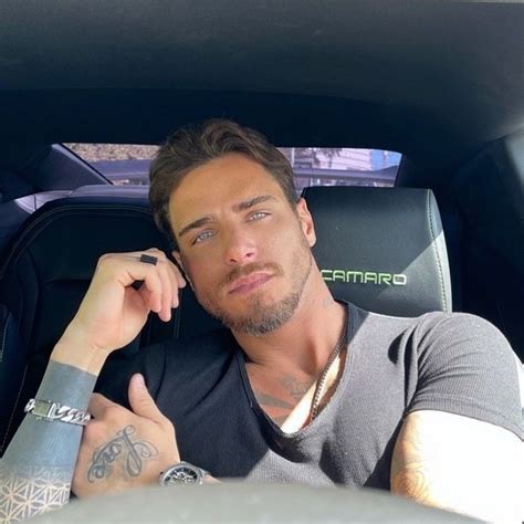 A Man Sitting In The Back Seat Of A Car Talking On A Cell Phone While