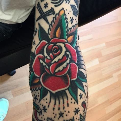 A Person With A Rose Tattoo On Their Arm