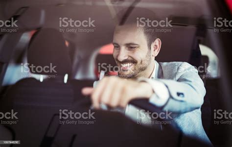 Attractive Happy Young Man Driving Car And Smiling Stock Photo