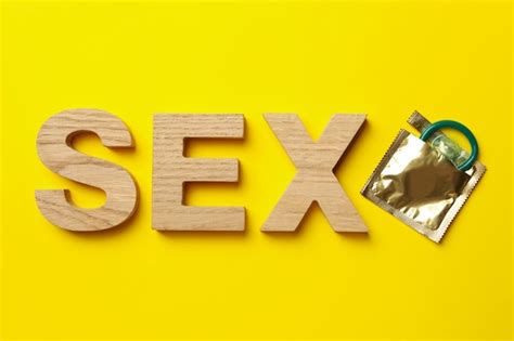 Palabra Sexo De Letras De Madera Y Condón En Superficie Amarilla Foto