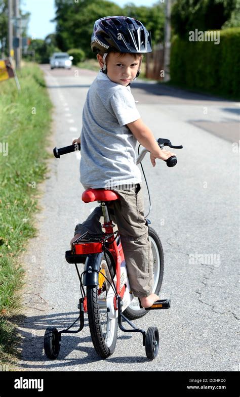 Boy Riding A Bicycle With Training Wheels Stock Photo Alamy