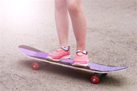Girl In Pink Sneakers On A Skateboard Feet On A Skateboard Stock Photo