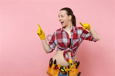 身穿格子衬衫牛仔短裤黄色手套件工具带的强壮年轻有趣的勤杂工女人高清图片下载 正版图片 摄图网