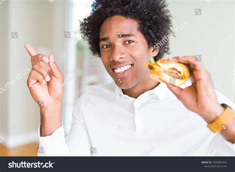 Hombre Afroamericano Hambriento Comiendo Hamburguesa Para Foto De Stock