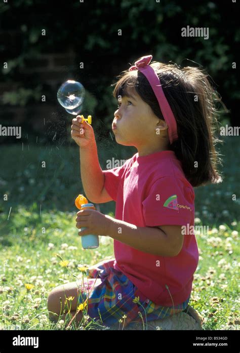 Little Girl Blowing Bubbles Outdoors In Sunshine Stock Photo Alamy