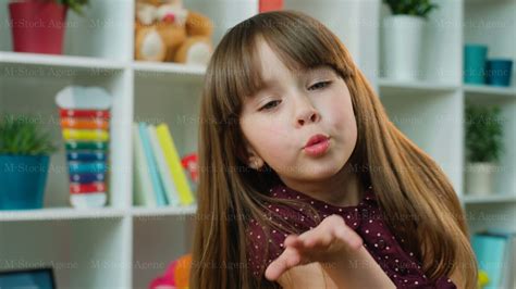 Cute Little Girl Blowing Kisses At The Camera In Kids Room White