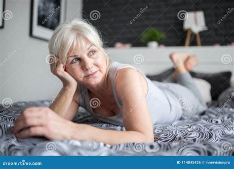 Senior Pensive Lady Lying On Bed Looking Away Stock Photo Image Of