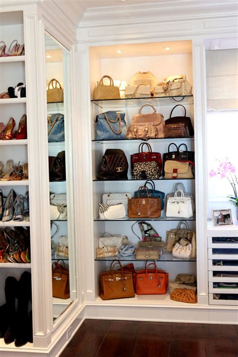 The Closet Is Full Of Purses And Handbags On Shelves In Front Of A Window