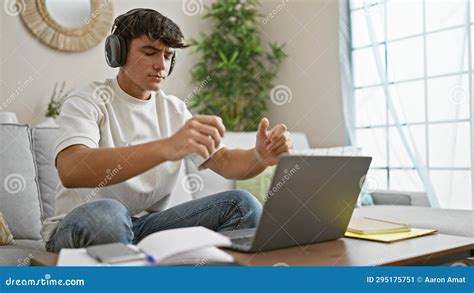 Engrossed Young Hispanic Male Student Chilling At Home Sitting On