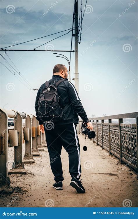 Male Photographer Traveler With Backpack And Camera In Hand Walking On