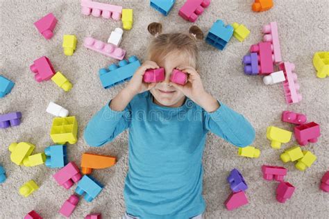 Cute Little Girl Playing With Colorful Building Blocks On Floor Top