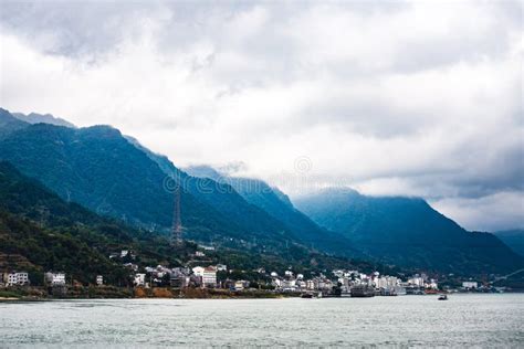 Small Town At Yangtze River`s Edge With Mountain And Cloud Background