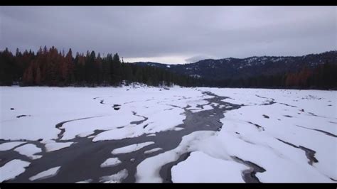 Wide Angle Flyover Of Frozen Lake With Cracked Ice Surface Near
