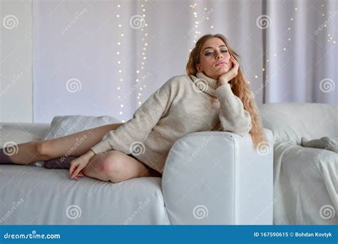 Girl Lying On Sofa In Sweaters And Socks And In Black Underwear Stock