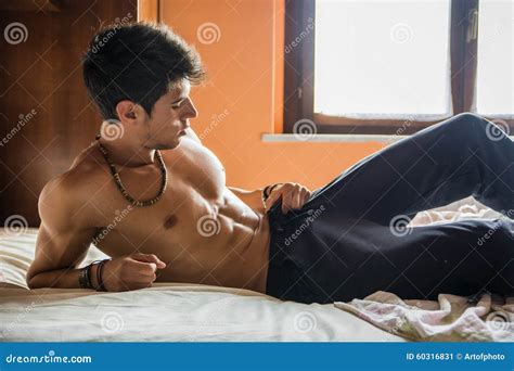 shirtless male model lying alone on his bed stock image image of blinds tempting 60316831