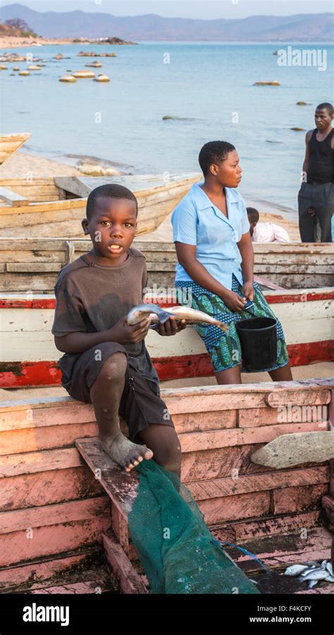 Local Boy With Fish From The Returning Fishermens Catch Likoma Island