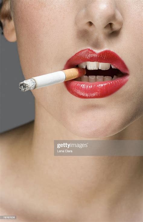 A Woman Wearing Red Lipstick And Smoking A Cigarette High Res Stock