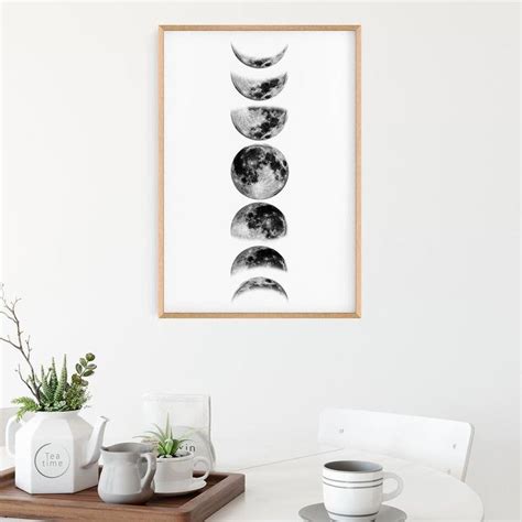 Three Phases Of The Moon In Black And White On A Wall Above A Dining Table