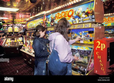 Girls Playing On The Penny Slot Machines In An Amusement Arcade