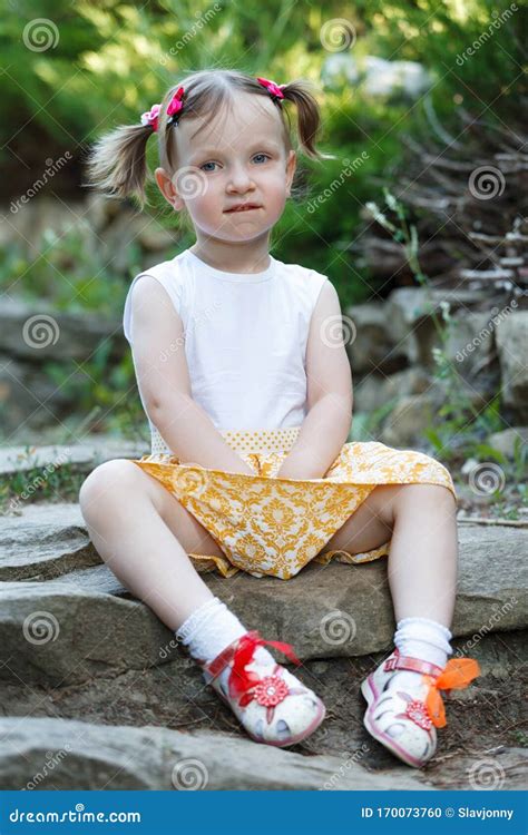 Portrait Of A Cute Little Girl On The Background Of Nature She`s