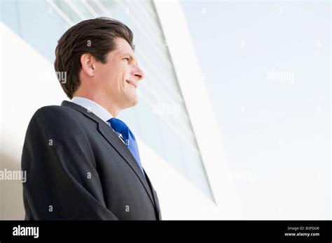 Businessman Standing Outdoors By Building Smiling Stock Photo Alamy