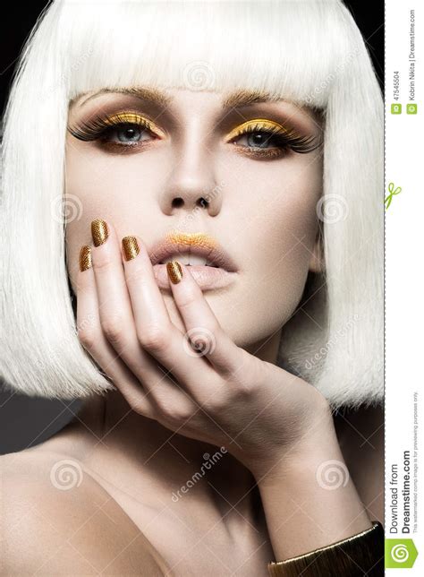 Beautiful Girl In A White Wig With Gold Makeup And Nails