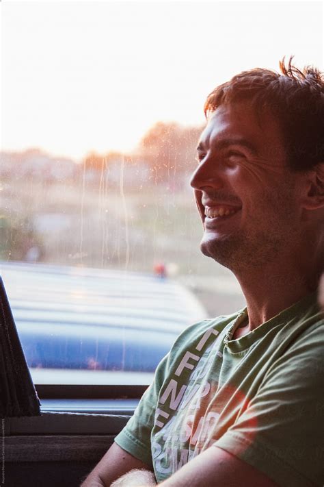 Young Man Laughing Traveling In A Bus At Sunset Del Colaborador De
