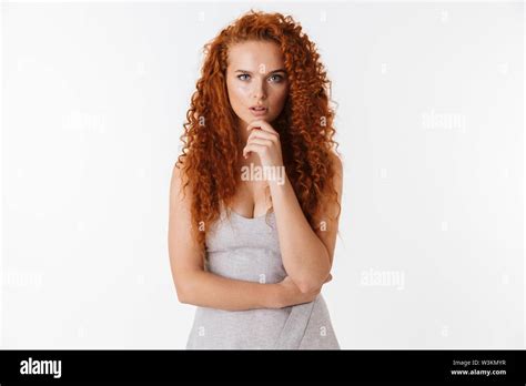 Portrait Of An Attractive Pensive Young Woman With Long Curly Red Hair