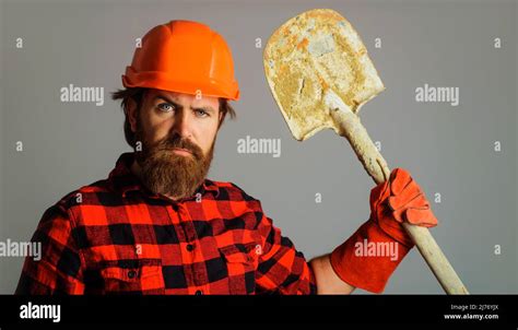 Bearded Construction Worker In Hard Hat With Spade Builder In Work