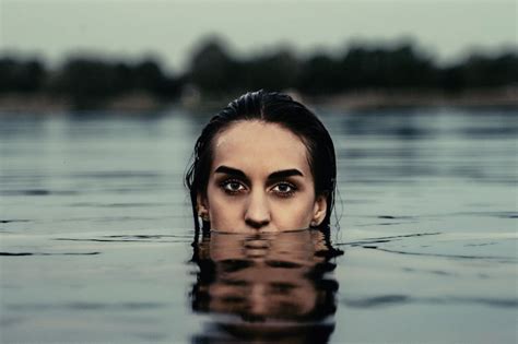 A Woman Is Submerged In The Water With Her Eyes Open