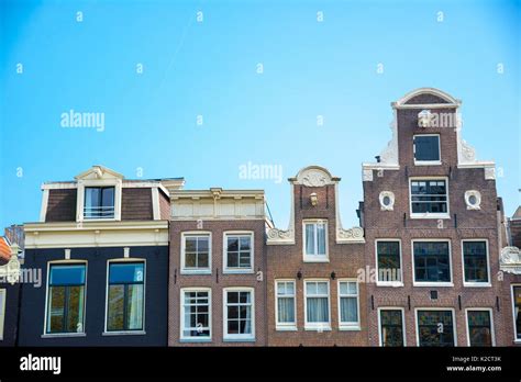 Typical Old Houses Of Amsterdam Netherlands Under Blue Sky Stock Photo