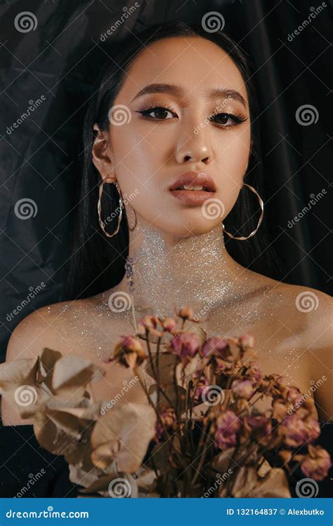 creative and artistic portrait of an asian beautiful girl with visage on a black background