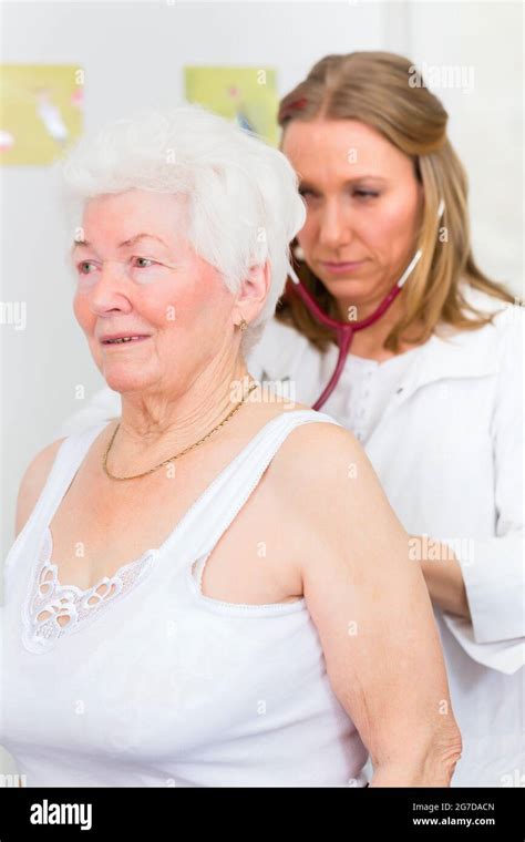 Female Doctor Auscultate Breath And Lungs Of Pensioner With Stethoscope