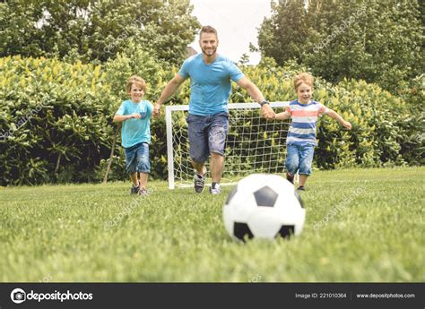 Man With Child Playing Football Outside On Field — Stock Photo © Lopolo
