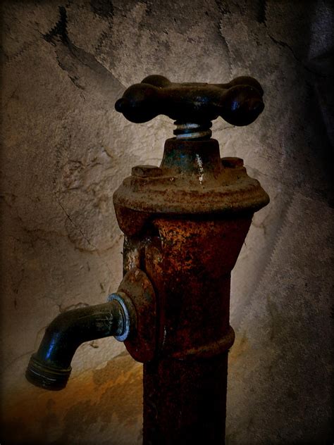 Closeup landscape shot of dripping water in the faucet with blurred in the vintage bathtub faucet and ceramic tiles in background. Vintage Water Faucet Photograph by Heinz G Mielke