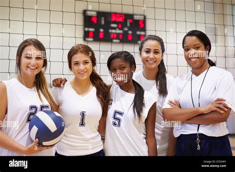 Members Of Female High School Volleyball Team With Coach Stock Photo