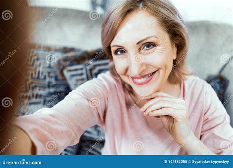 beautiful middle aged woman in casual clothes is making selfie stock image image of room