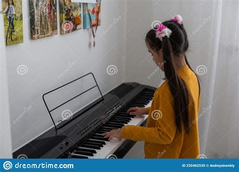 Beautiful Girl Sings While Playing On An Electronic Piano Stock Image