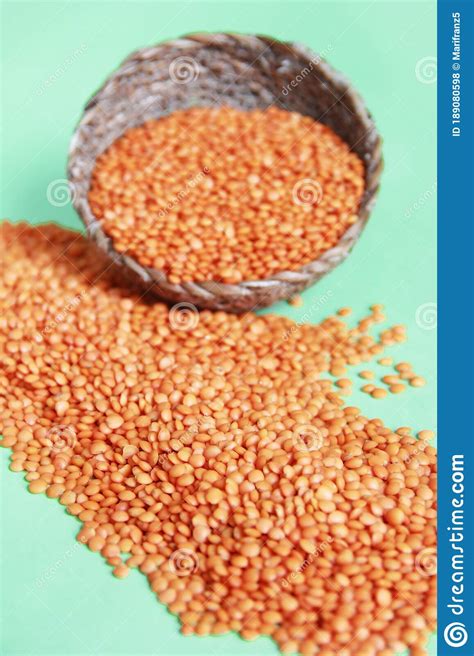 Small Dry Grains Of Red Lentils On A Green Background Stock Photo