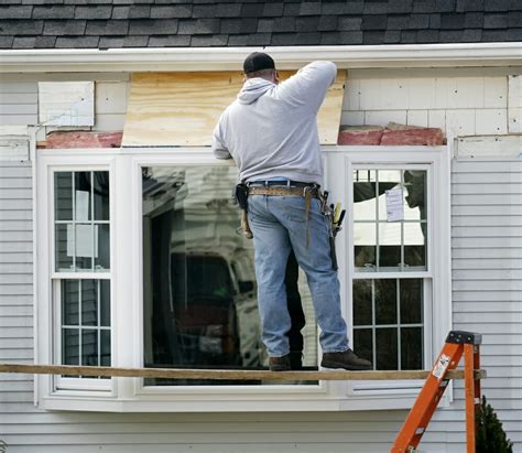 A Contractor Installs A Bay Window Into A Home