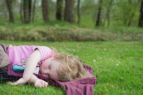 Toddler Girl Taking A Nap Outdoors Stock Photo Dissolve