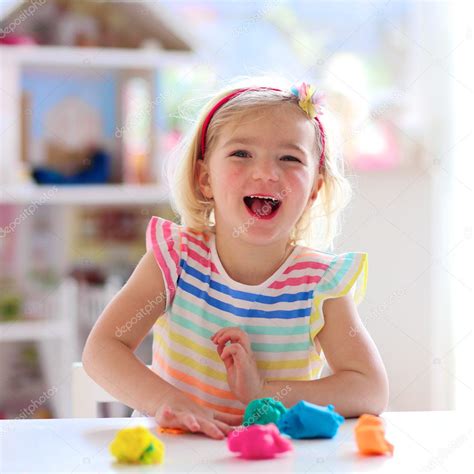Preschooler Girl Playing Indoors With Plasticine Stock Photo By