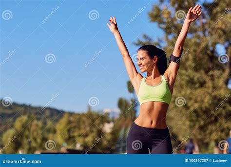 A Girl Runner Smiling Raised Her Hands Up In The Park Stock Image