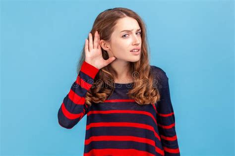 Woman Wearing Striped Sweater Holding Hand Near Ear And Listening