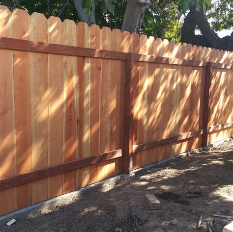 Redwood fence with a concrete footing